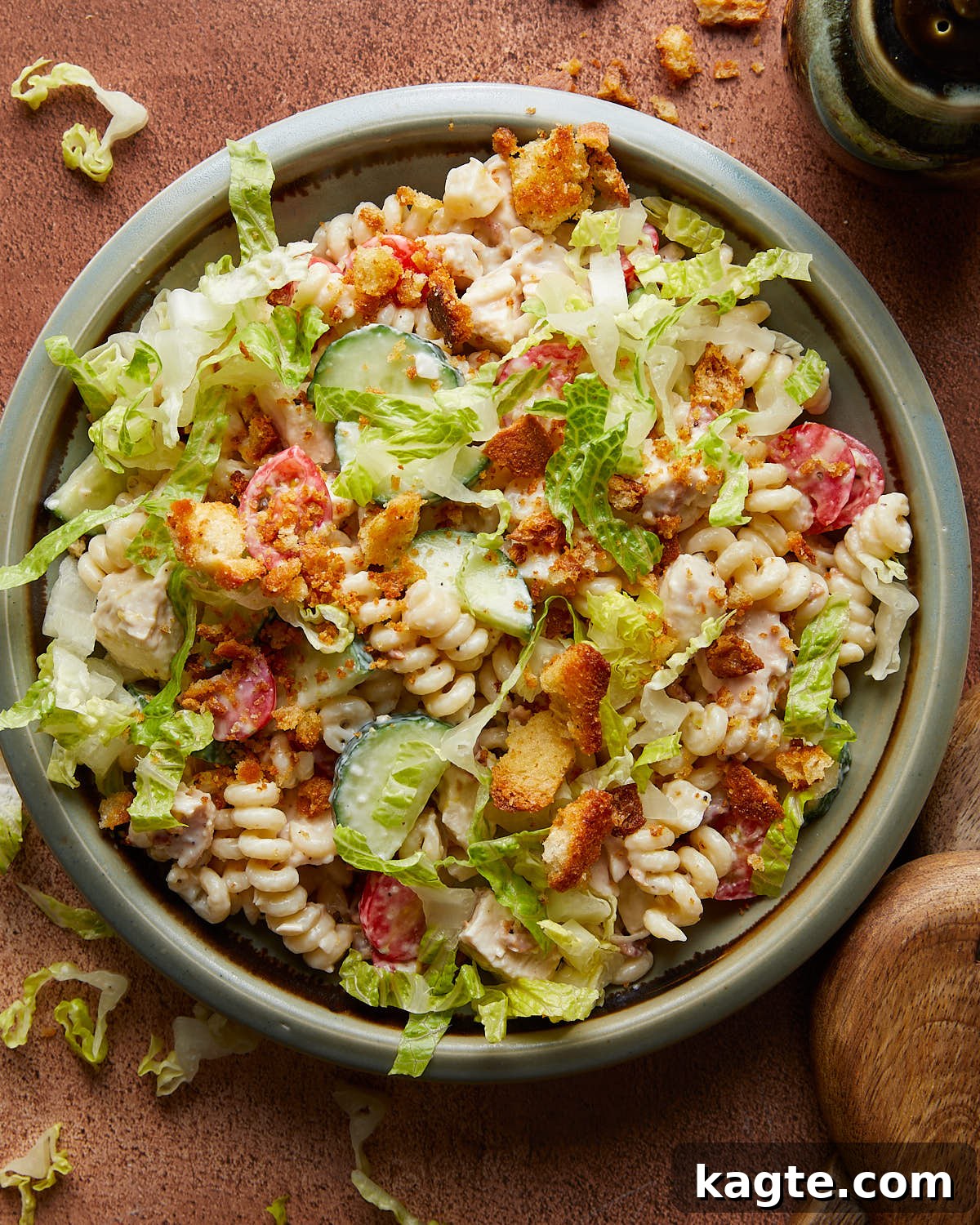 Overhead image of chicken caesar pasta salad in blue dish. 