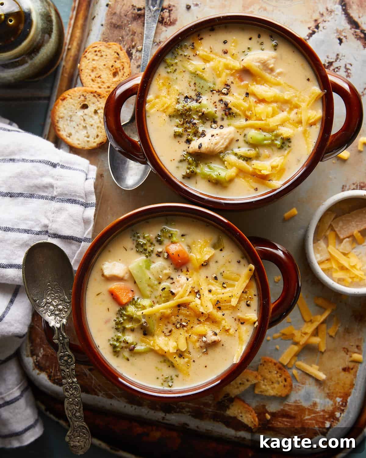 Protein Packed Chicken Broccoli Cheddar Soup 2 Overhead image of chicken broccoli cheddar soup in two brown soup bowls with garnish.