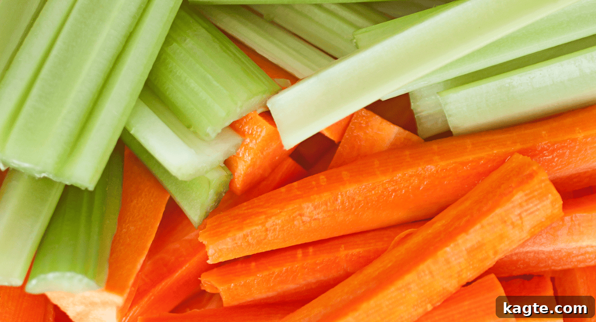 A vibrant platter featuring fresh, crisp celery sticks and bright orange carrot sticks, perfectly cut for dipping, offering a refreshing contrast to rich dips.