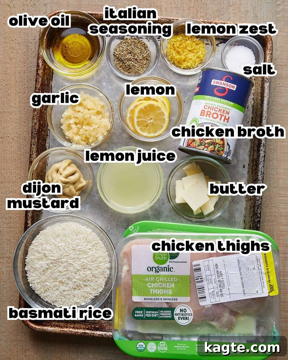 Zesty Lemon Chicken and Rice Bake 3 Overhead image of ingredients needed to make baked lemon chicken and rice on baking sheet.