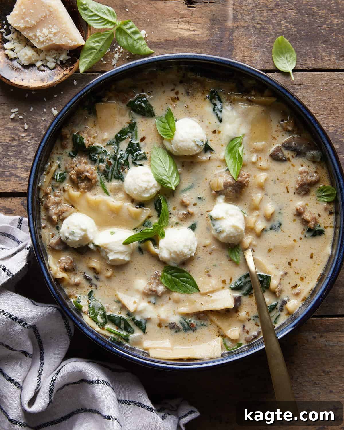 Velvety White Lasagna Soup with Zesty Italian Sausage 2 Overhead image of creamy white lasagna soup generously garnished with fresh herbs and Parmesan cheese, ready to be served.