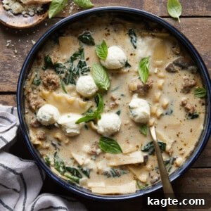 Velvety White Lasagna Soup with Zesty Italian Sausage 7 A bowl of creamy white lasagna soup garnished with fresh herbs and Parmesan, viewed from an angle.