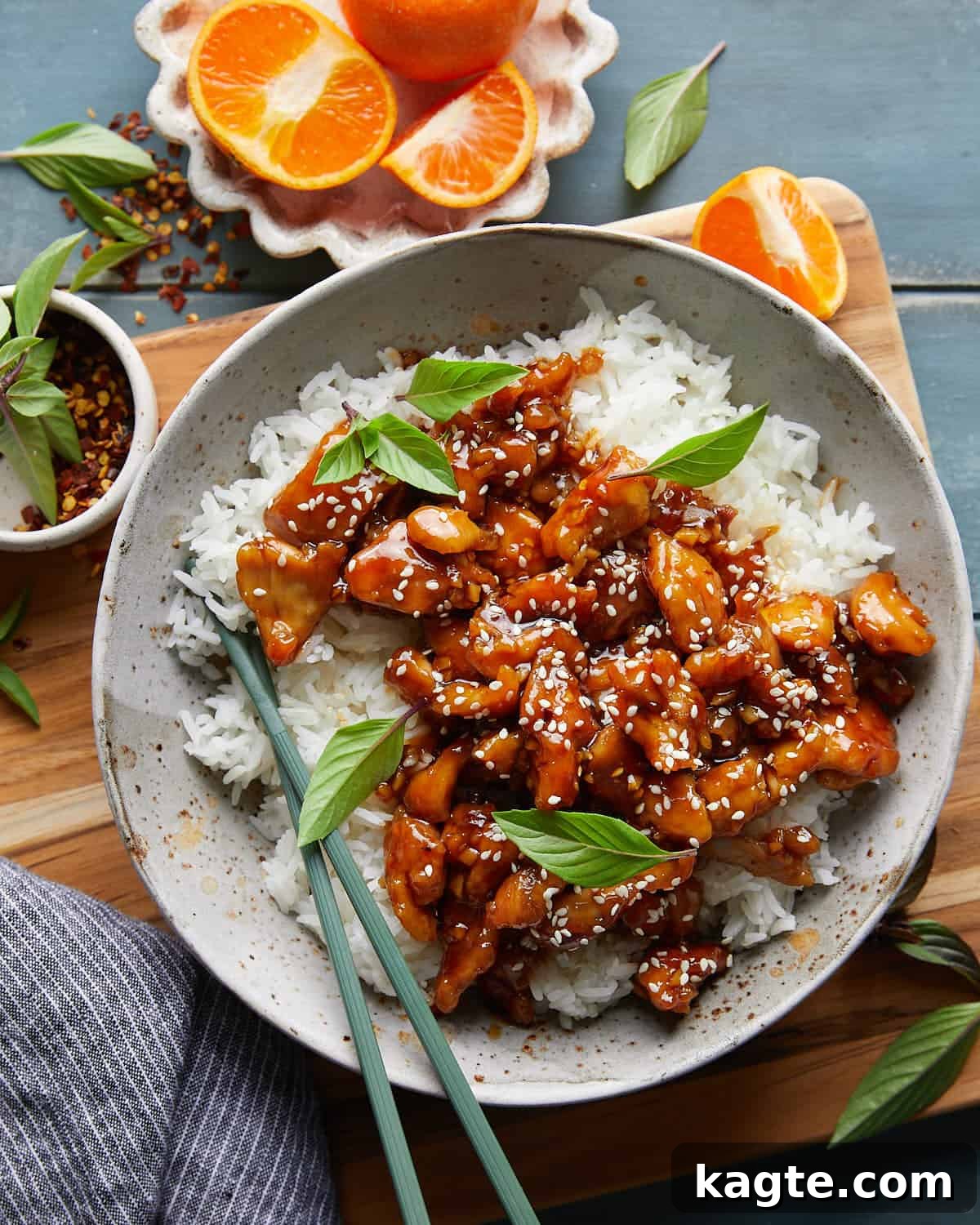 Overhead image of easy orange chicken on bed of white rice on white dish. 