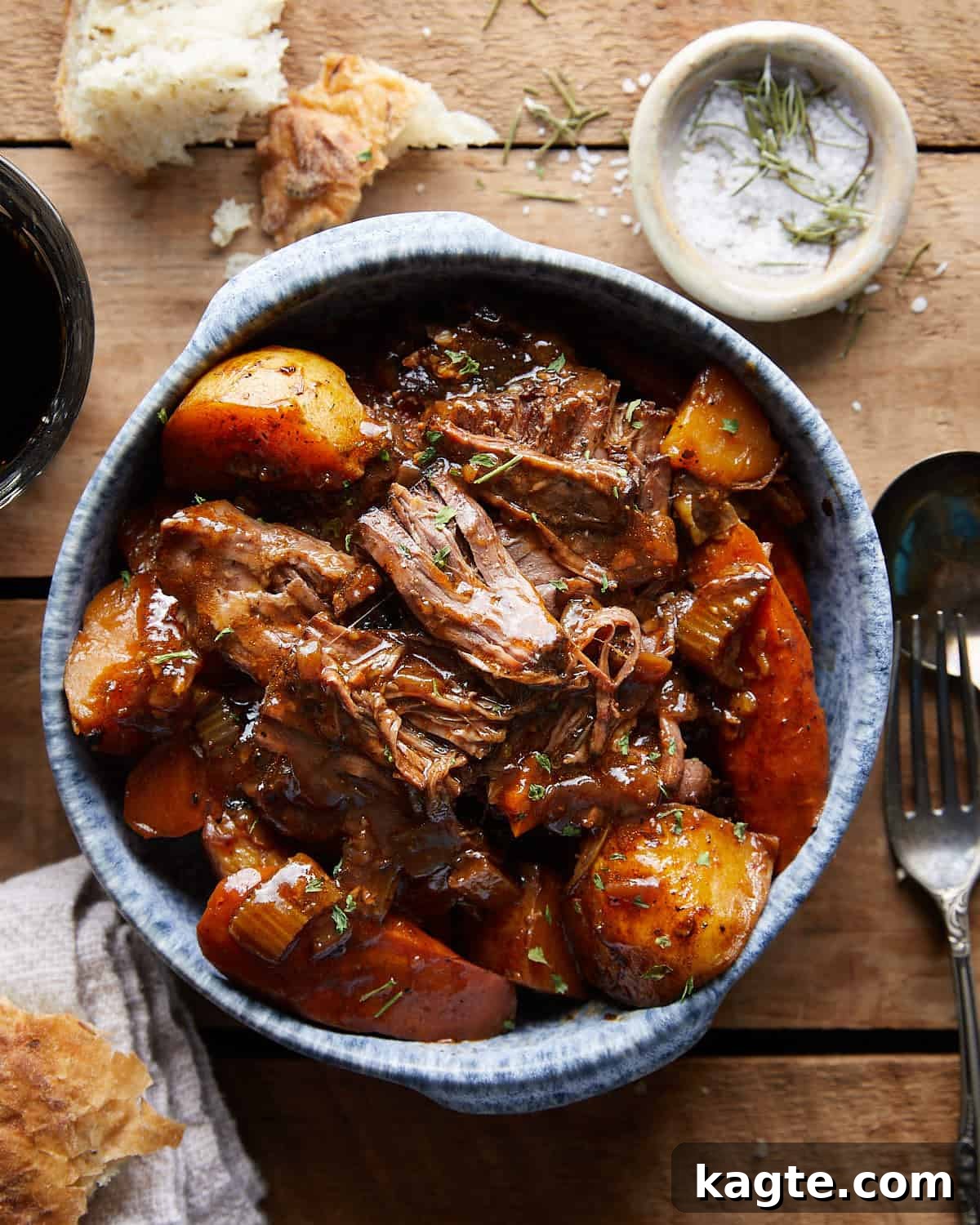 Overhead view of shredded Dutch Oven Pot Roast in a blue bowl.