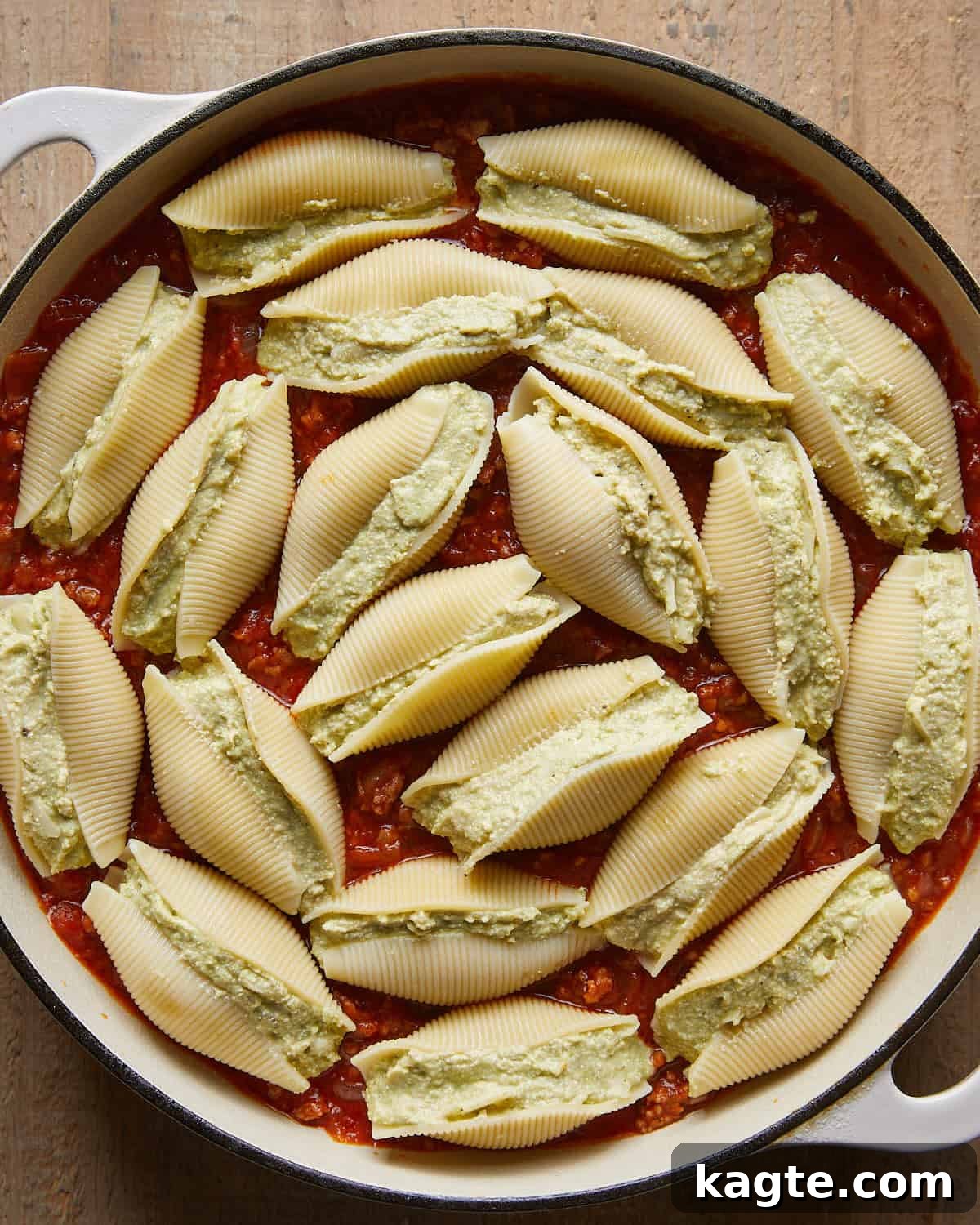 Stuffed shells nestled into meat marinara sauce in a baking dish for baked stuffed shells.