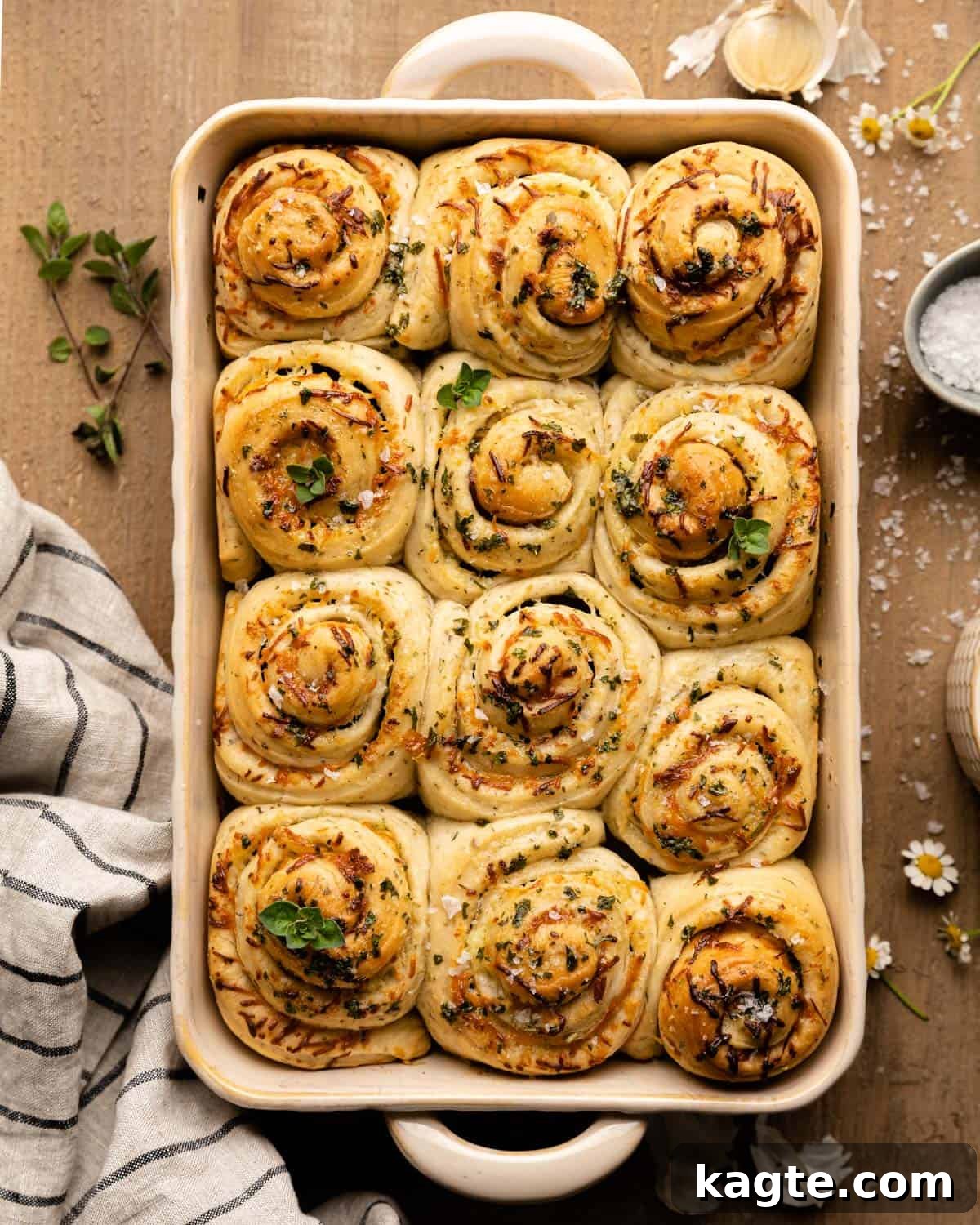 Cheesy Garlic Herb Swirl Rolls 2 Overhead view of freshly baked Cheesy Garlic Herb Butter Rolls in a baking dish, golden brown and glistening with butter.