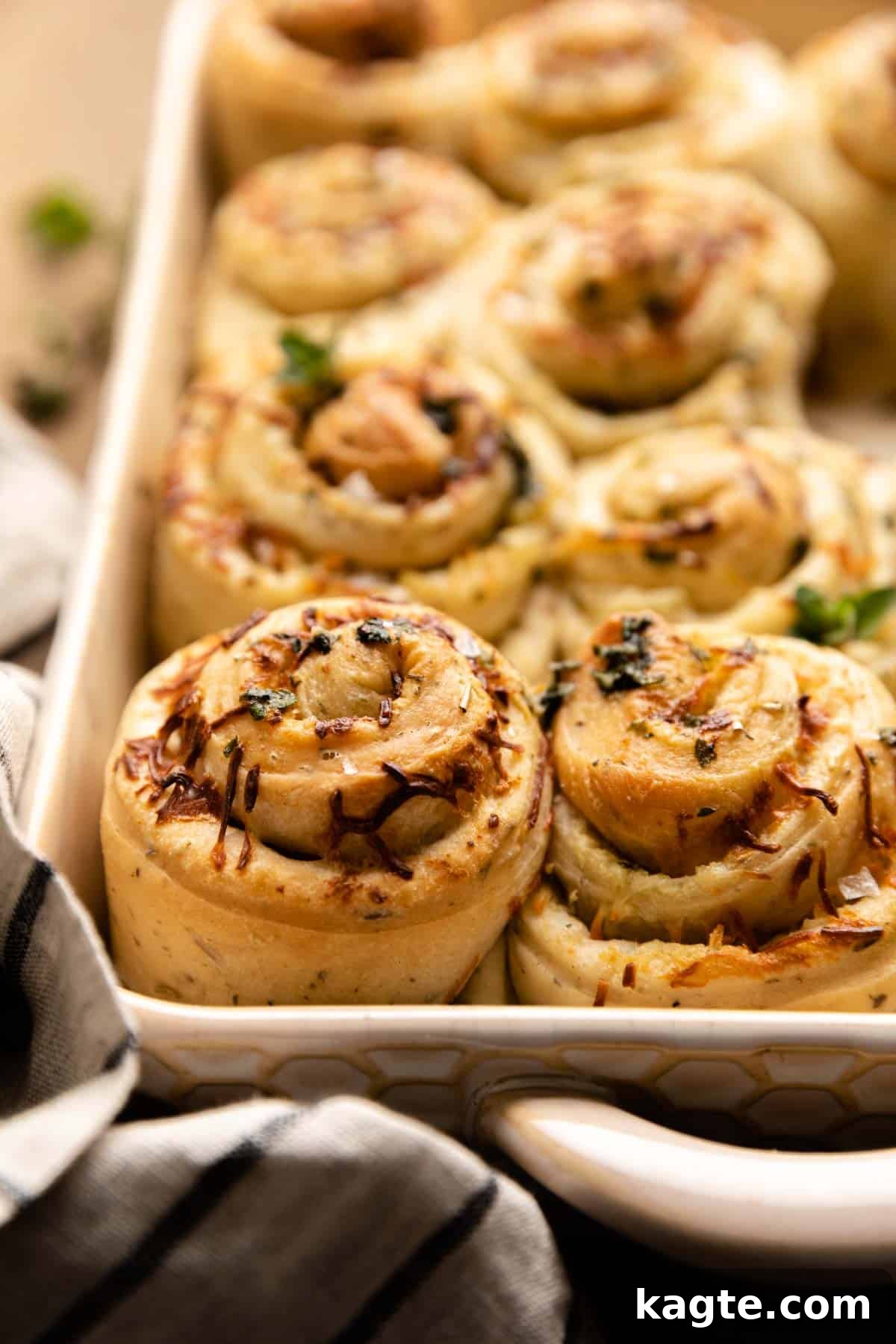 Cheesy Garlic Herb Swirl Rolls 13 Side view of a Cheesy Garlic Herb Butter Roll, showcasing the fluffy interior and visible layers of garlic, herbs, and melted cheese.