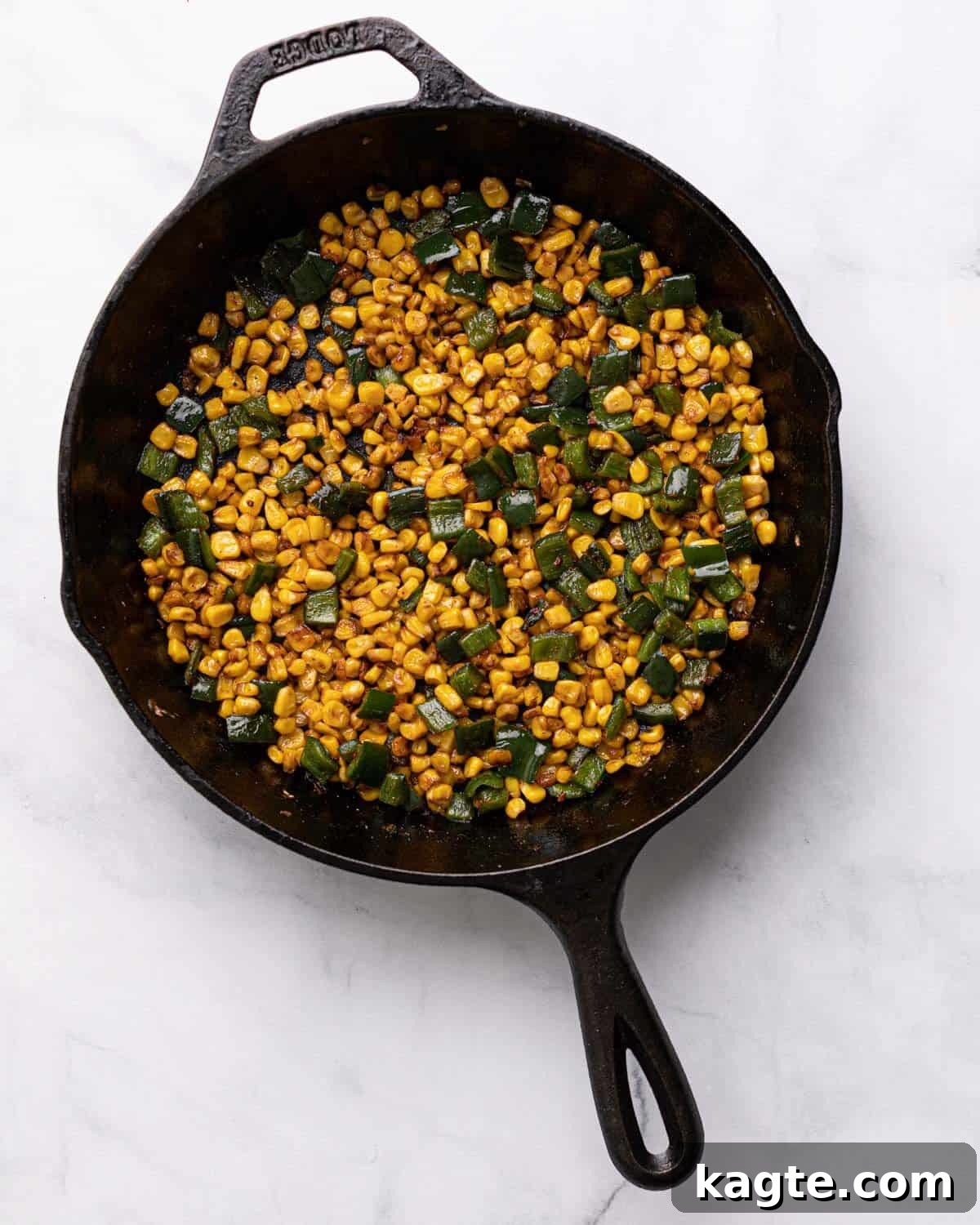 Melty Fiesta: Poblano-Corn Fundido 3 Sautéed corn and poblano peppers cooking in a cast iron skillet, golden brown and tender.