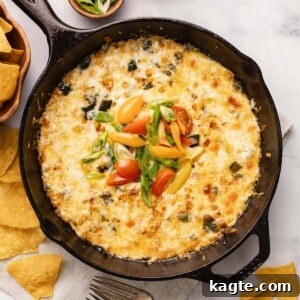 Queso Fundido with Poblano & Corn in a cast iron skillet, garnished with cilantro.