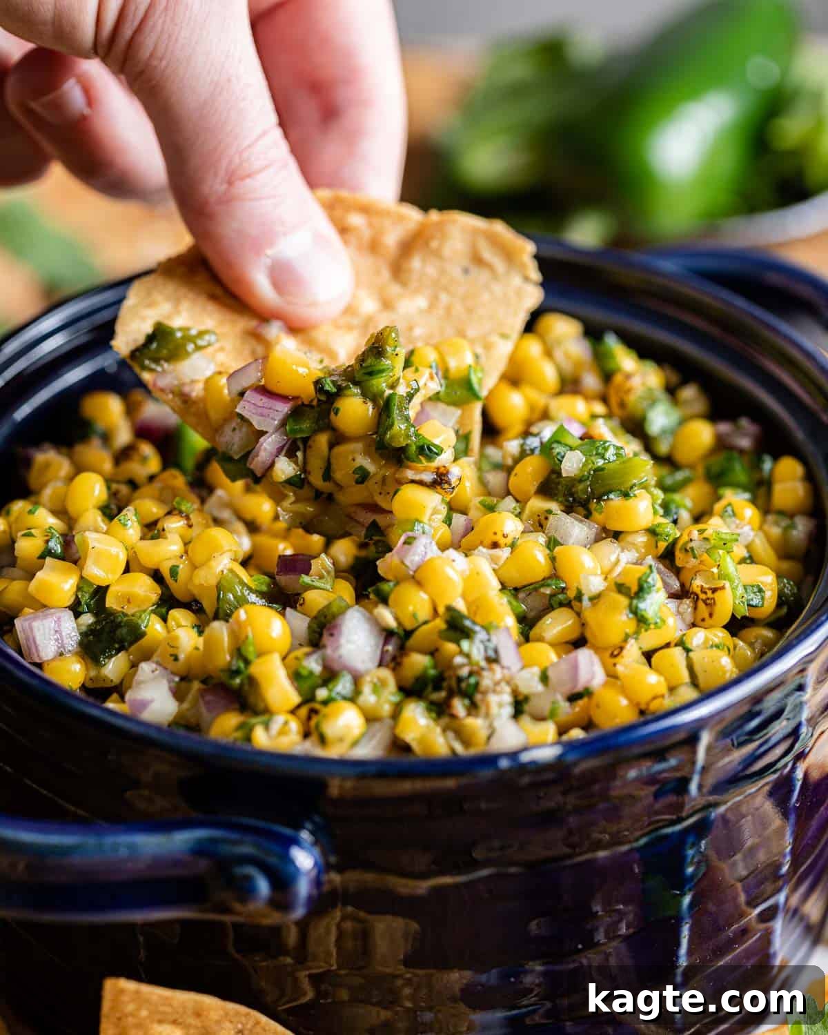 Smoky Sweet Corn & Chili Medley 8 chip being dipped in roasted chili corn salsa