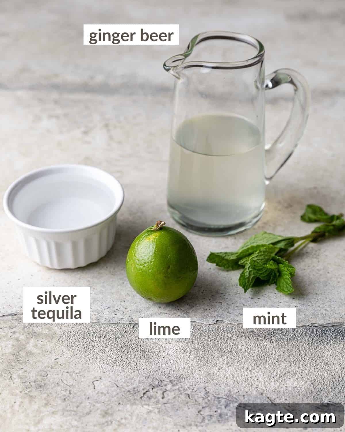 The Ultimate Mexican Tequila Mule 3 A visual display of the key ingredients required to craft a delicious Mexican Mule, including fresh limes, vibrant mint, a bottle of premium silver tequila, and crisp ginger beer.