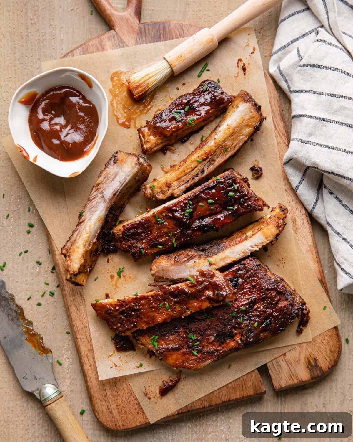 Fall-Off-The-Bone St Louis Ribs Oven Masterpiece 2 St louis rubs in oven on a cutting board with sauce on top.