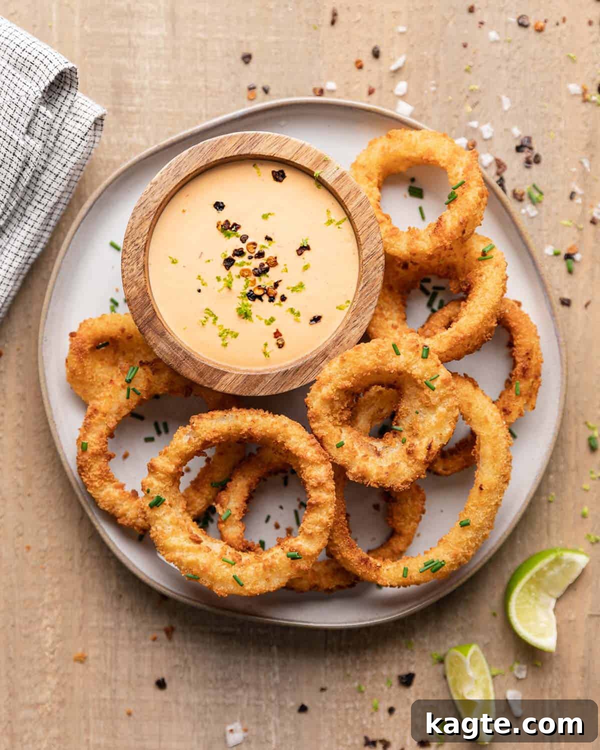 Smoky Chipotle Lime Crema 5 Overhead of onion rings and chipotle crema sauce on a plate.