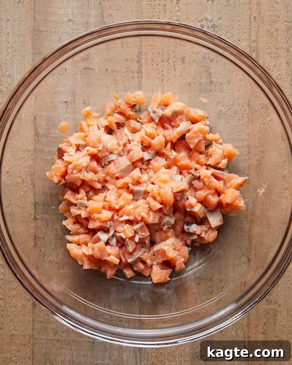 Flavor-Packed Salmon Burgers with Zesty Sriracha Aioli 4 Overhead close-up of finely chopped fresh salmon in a mixing bowl, ready to be mixed for Asian salmon burgers
