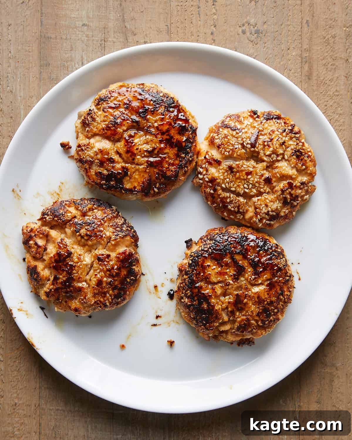 Flavor-Packed Salmon Burgers with Zesty Sriracha Aioli 8 Overhead image of perfectly cooked and seared Asian salmon burgers with crispy edges and tender centers.
