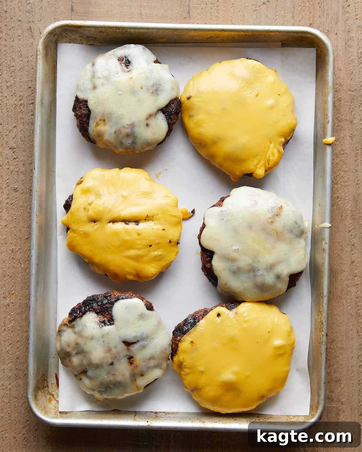 Juicy Grilled Hamburger Recipe for Perfect Backyard Burgers 6 Grilled burger patties topped with melted cheese.