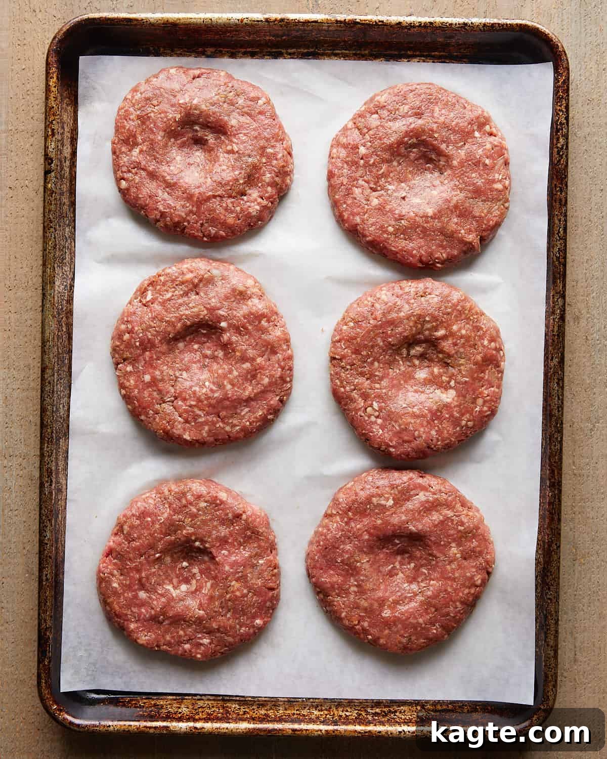 Top Meats for Juicy, Flavorful Burgers 4 Raw burger patties shaped and arranged on parchment paper.