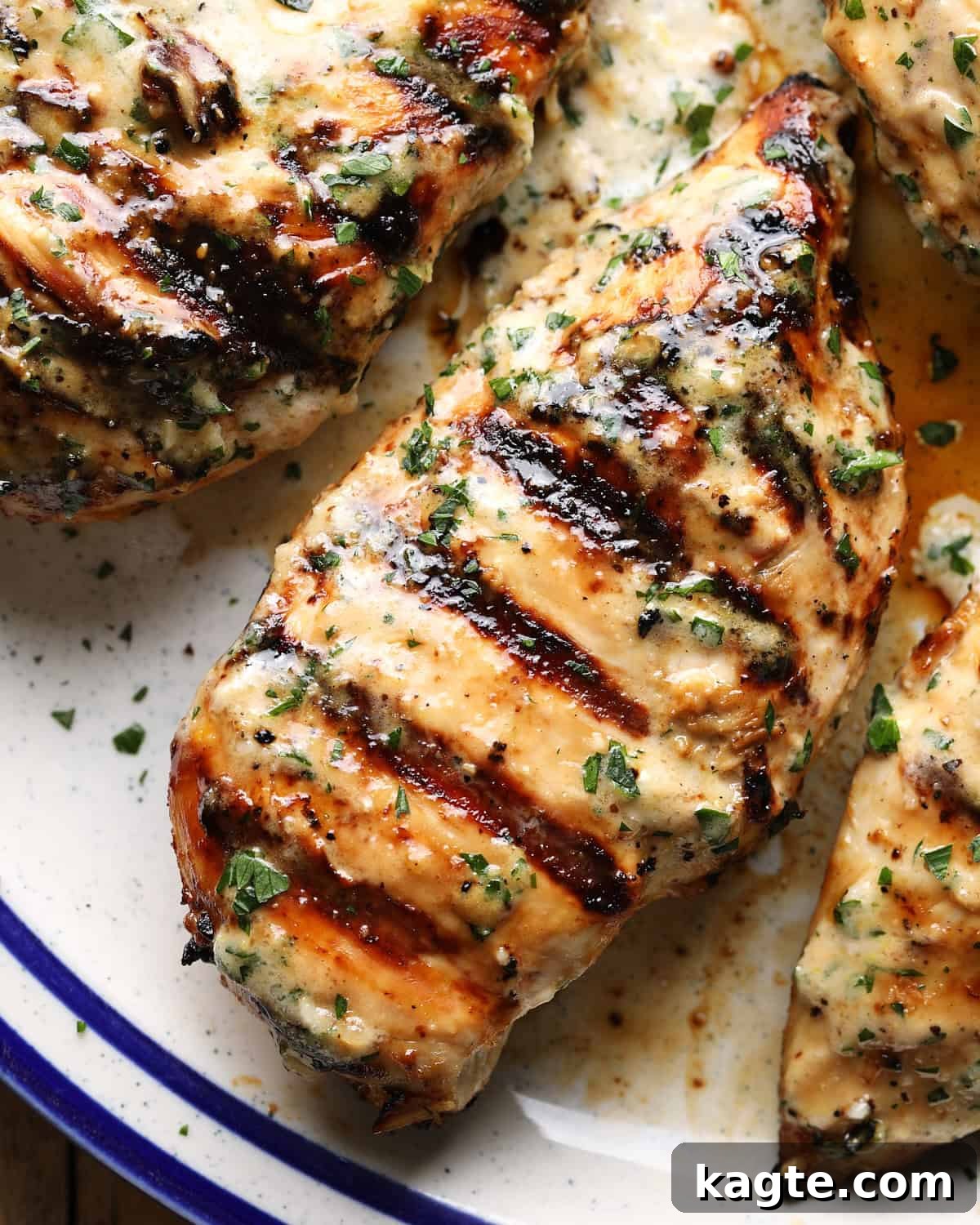 Grilled Chicken Marinated in Caesar Dressing 2 Close-up of sliced grilled Caesar chicken with grill marks and fresh herbs.