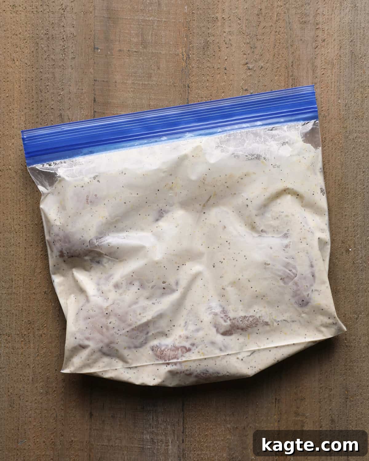 Grilled Chicken Marinated in Caesar Dressing 5 Chicken marinating in Caesar dressing inside a zip-top bag.