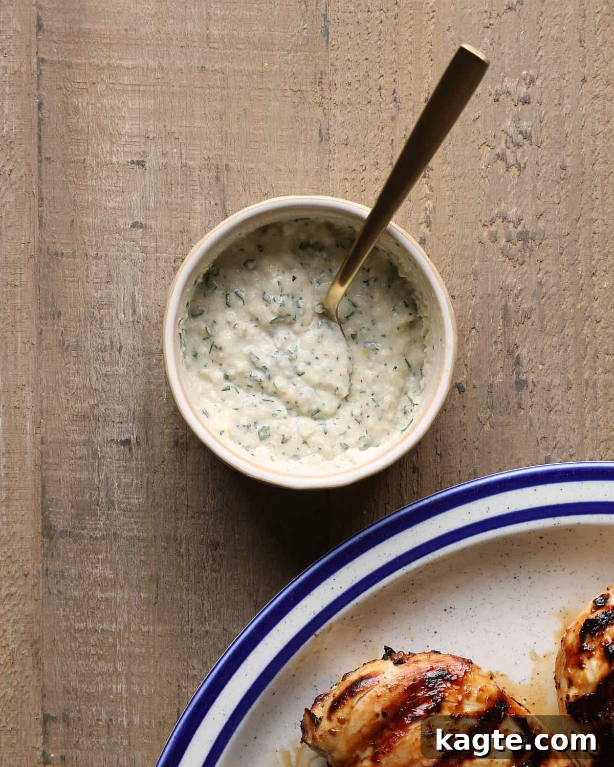 Grilled Chicken Marinated in Caesar Dressing 7 Creamy Caesar finishing sauce in a small bowl with grilled chicken in the background.