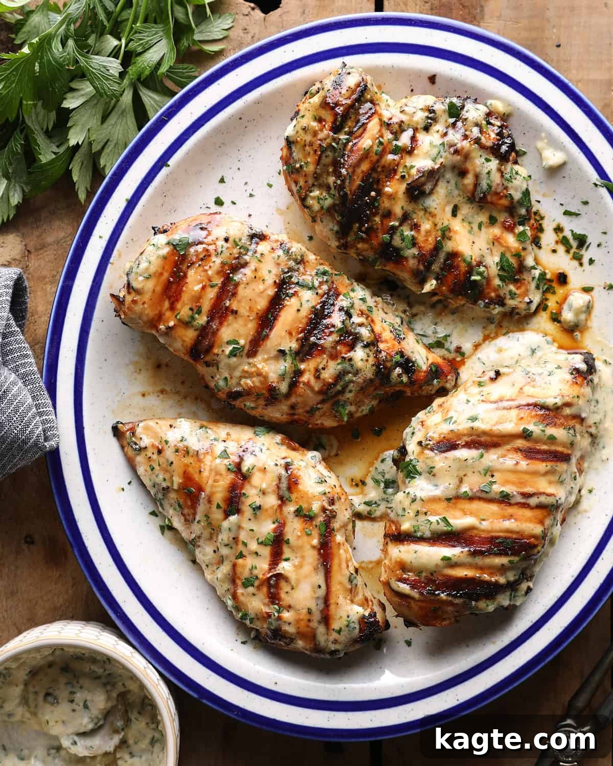 Grilled Chicken Marinated in Caesar Dressing 8 Overhead photo of grilled Caesar chicken breasts topped with herbs and served with Caesar sauce.