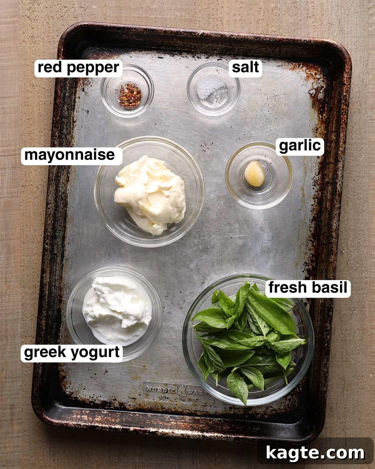 Creamy Homemade Basil Aioli 3 Labeled ingredients for basil aioli arranged on a sheet pan, including mayonnaise, Greek yogurt, fresh basil, garlic, salt, and red pepper flakes.