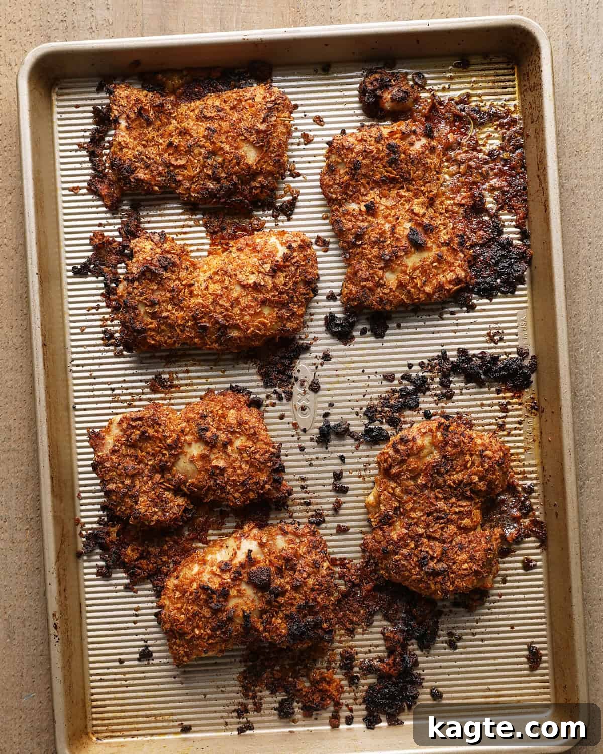Crispy Baked Cornflake-Crusted Chicken Thighs 8 Baked cornflake chicken thighs with a browned coating on the baking sheet.