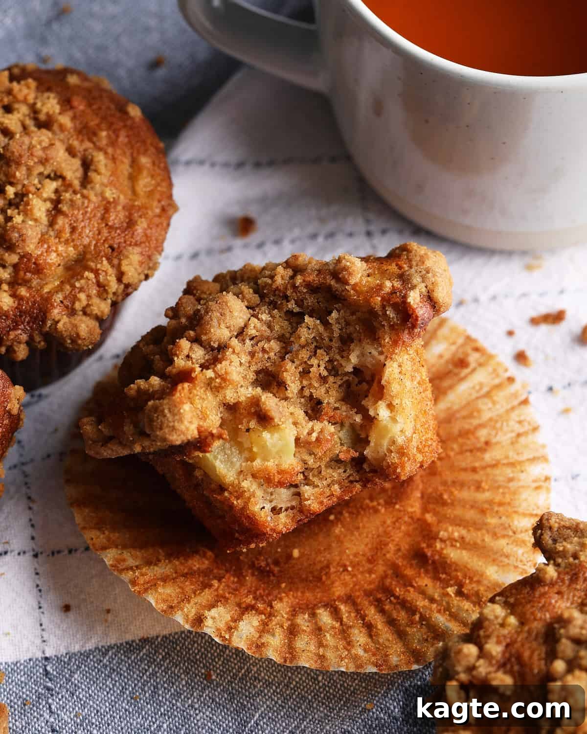 Apple Cider Muffins with Cinnamon Crumb Topping 9 Apple cider muffin split open to show diced apple pieces and cinnamon crumb topping.