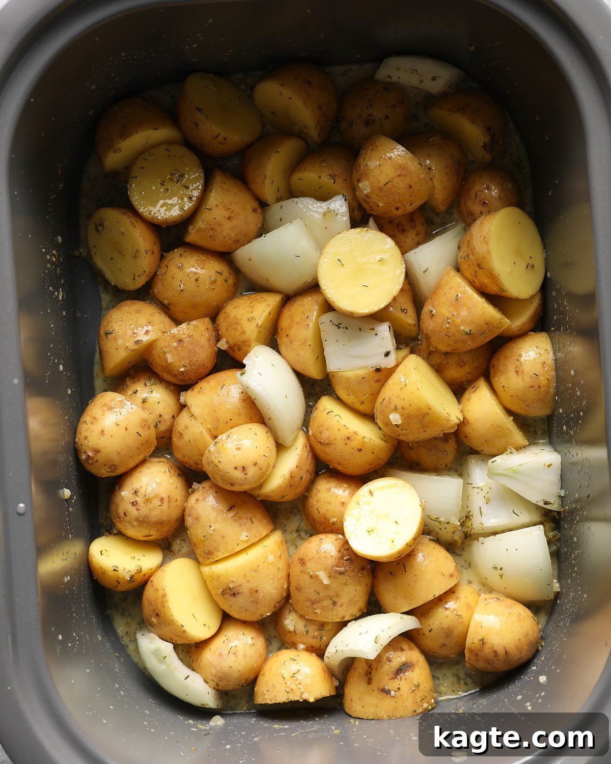 Slow Cooker Greek Lemon Chicken and Potatoes 5 Yellow potatoes and onion wedges coated in lemon Dijon broth in a slow cooker.