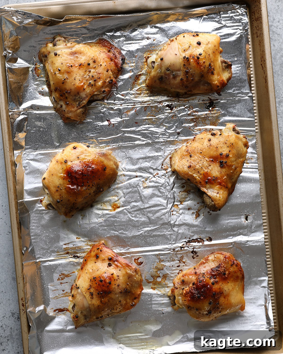 Slow Cooker Greek Lemon Chicken and Potatoes 8 Greek lemon chicken thighs browned beneath the broiler on a foil-lined pan.