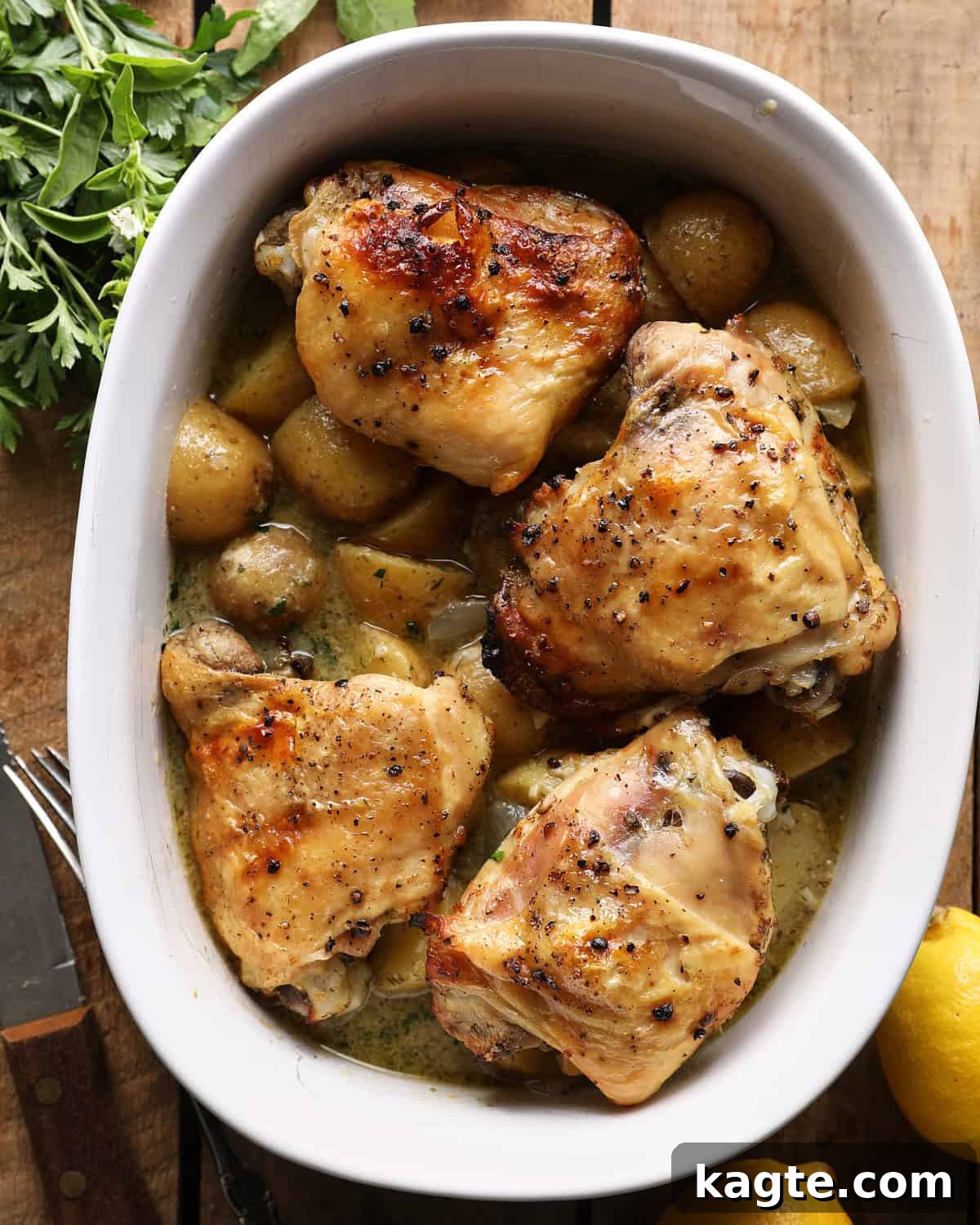 Slow Cooker Greek Lemon Chicken and Potatoes 9 Broiled bone-in chicken thighs with potatoes and lemon broth in a white dish.