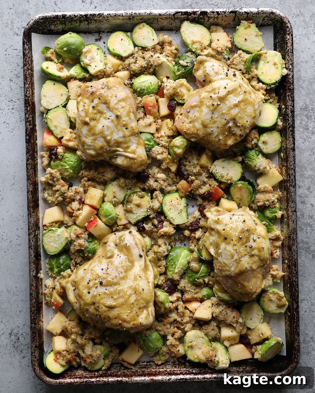 Sheet Pan Roasted Chicken with Herb Stuffing 6 Four maple Dijon-coated chicken thighs arranged skin-side up on the stuffing and vegetable mixture before roasting.